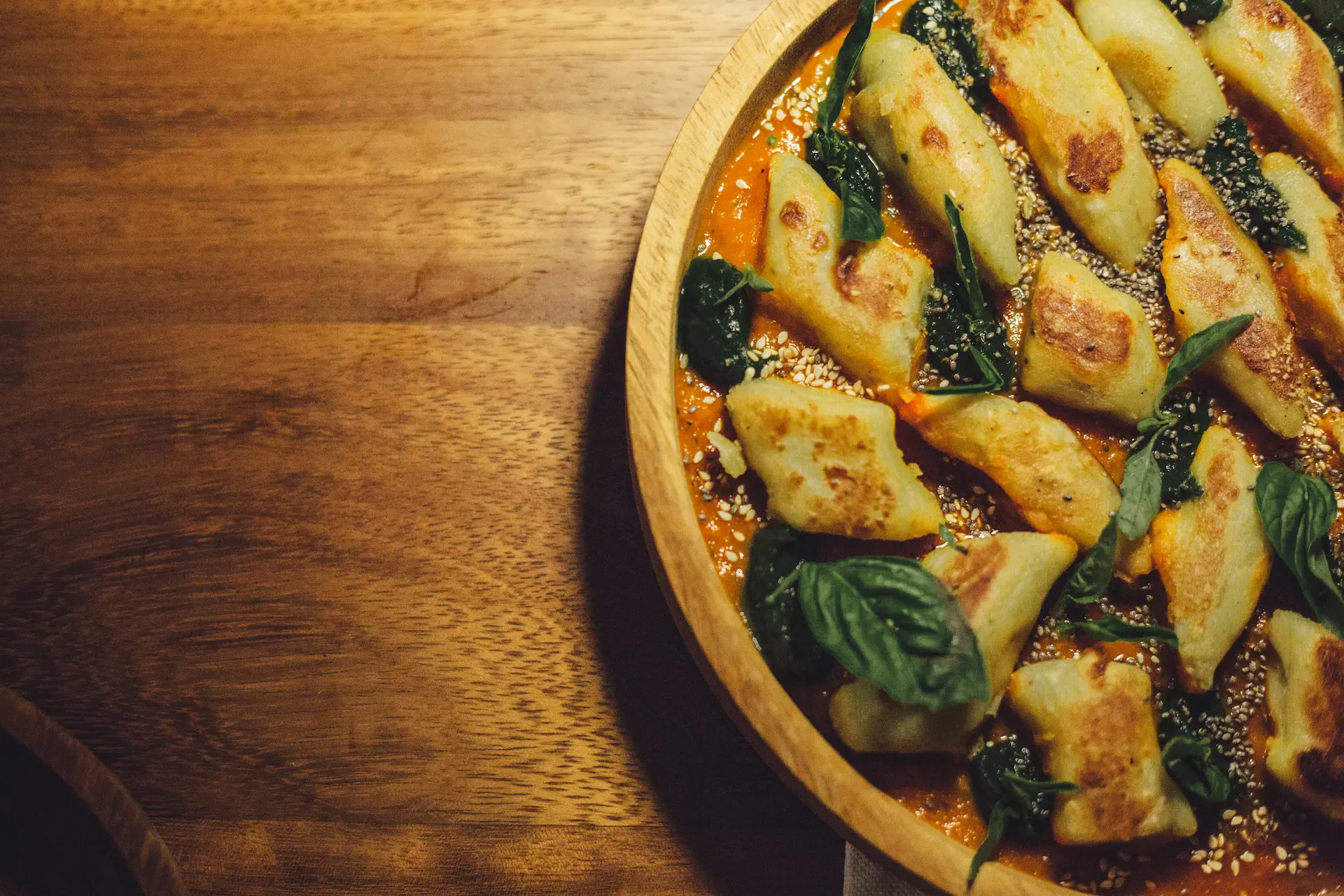 Pan-fried gnocchi in tomato sauce with spinach