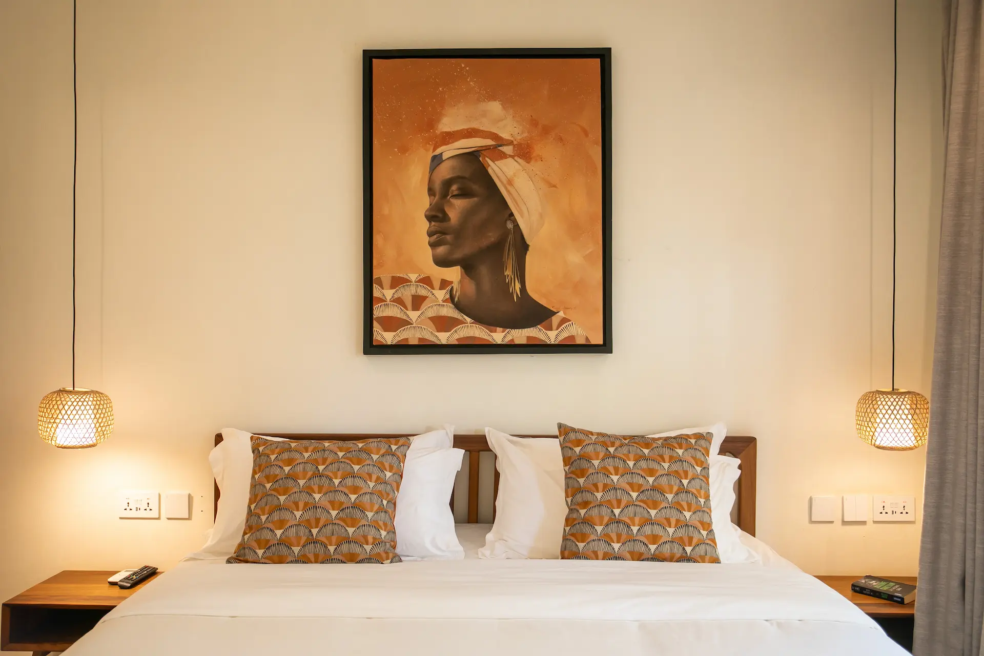Meditator room â€” double bed with bamboo pendant lights and African portrait artwork
