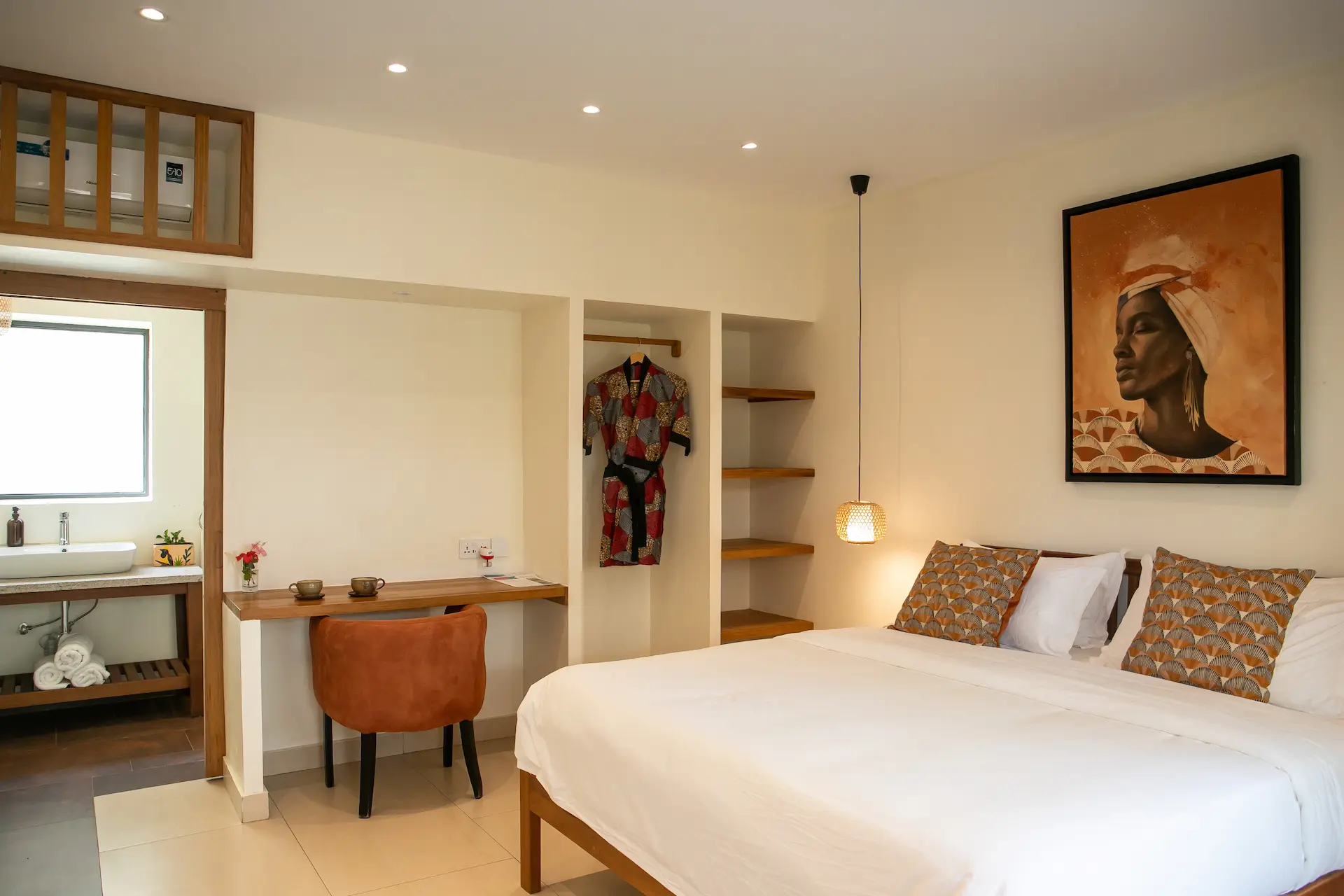 Meditator room â€” double bed, open wardrobe with African print robe and desk
