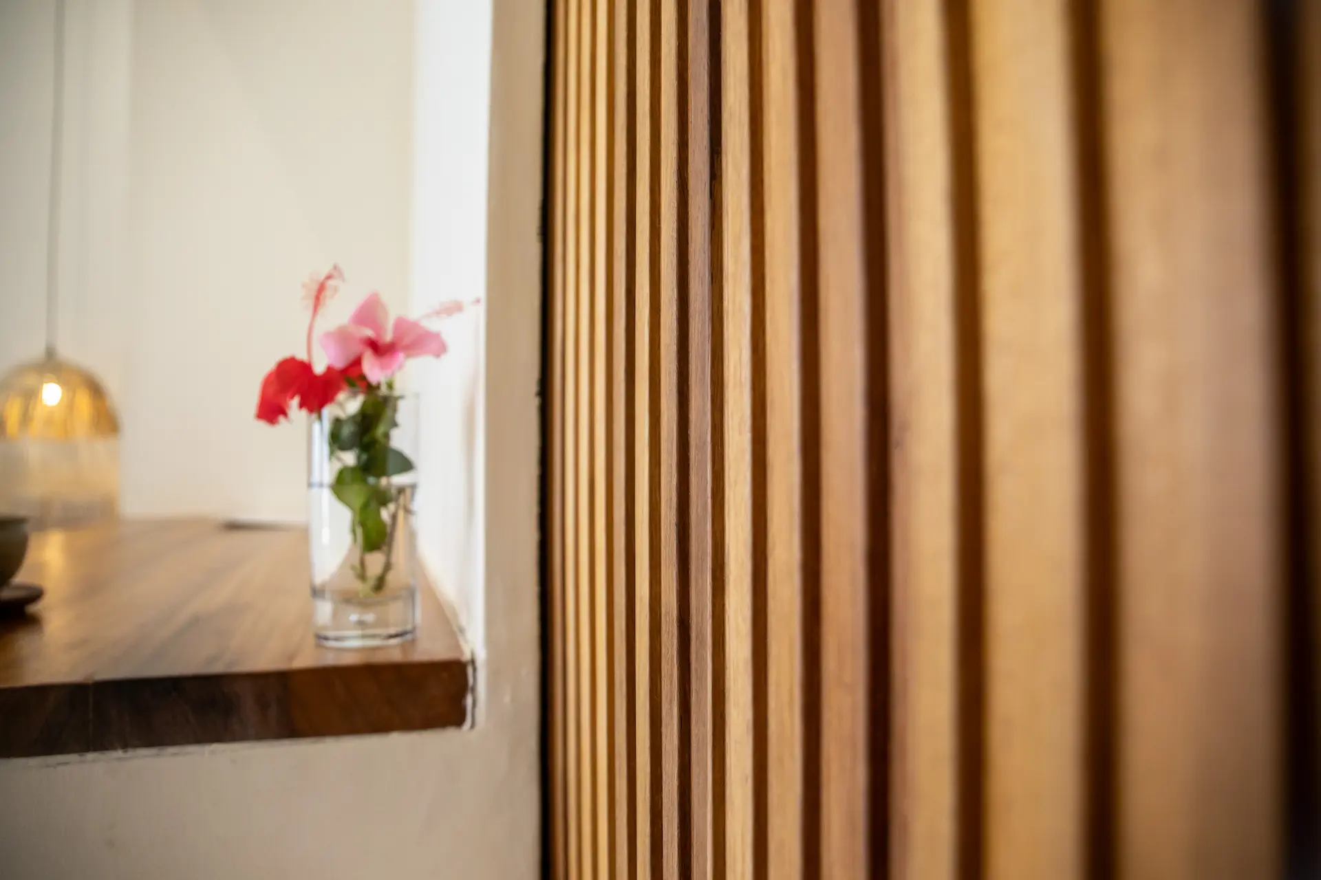 Detail â€” wooden slat door with hibiscus flowers