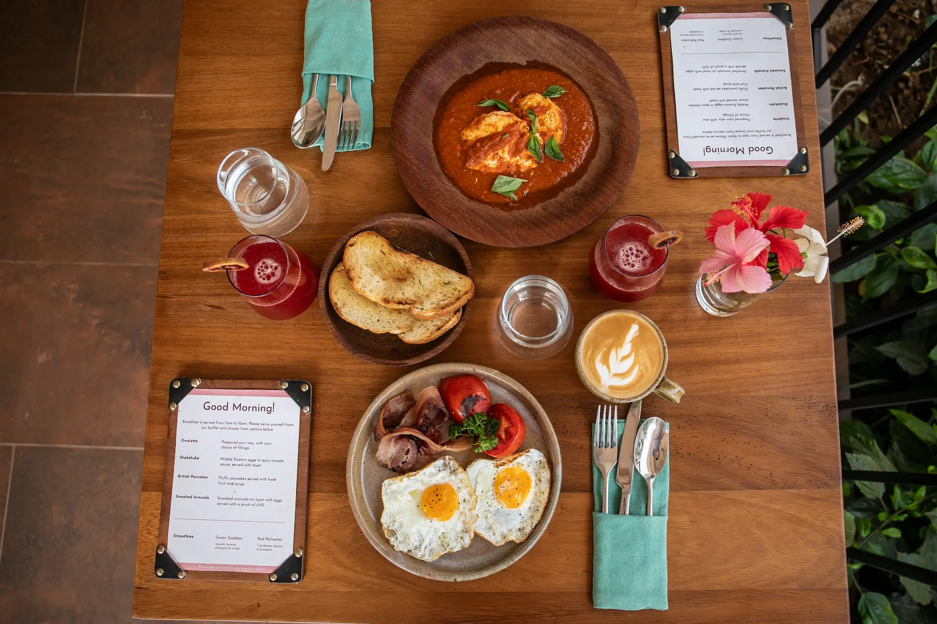 Overhead breakfast spread with shakshuka, eggs and fresh juice